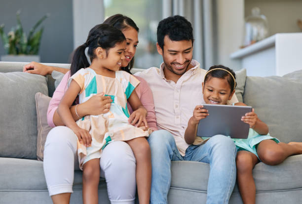 istock Shot of a young family relaxing together while using a digital tablet 1369716592