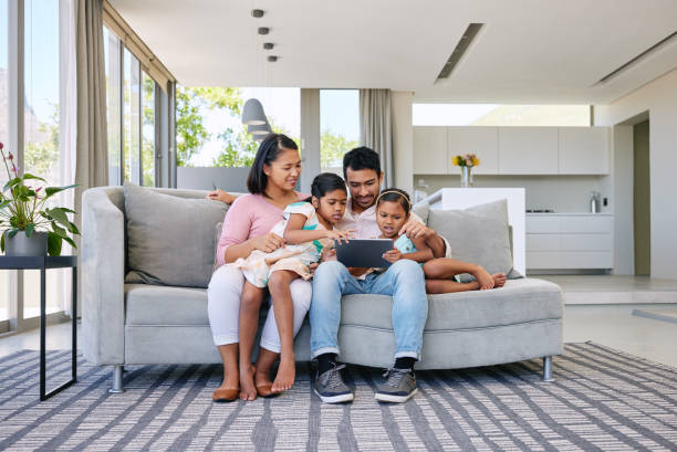 istock Shot of a young family relaxing together while using a digital tablet 1369716644