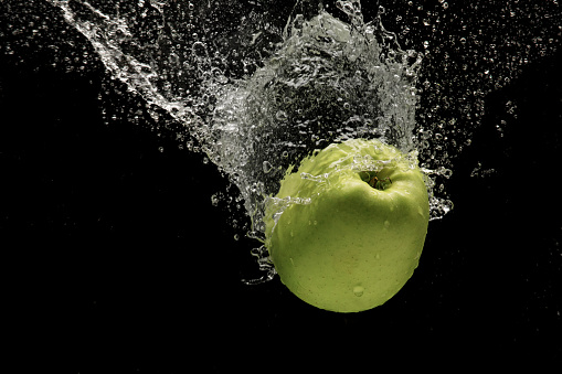 Fresh green apple in a Water splash studio shot