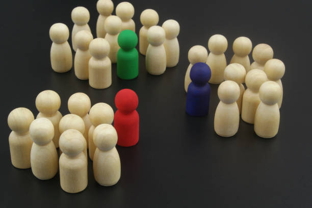 istock Wooden people figures divided into groups with leaders. 1369717763