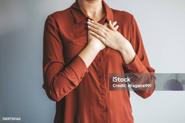 Kind Smiling Young Woman Feeling Thankful Stock Photo - Download Image Now - Honesty, Respect, Admiration