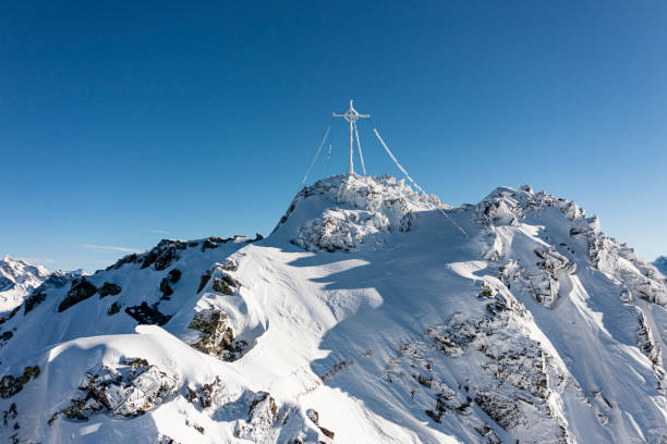 Frozen summit cross on top of a mountain. Vorarlberg, Montafon