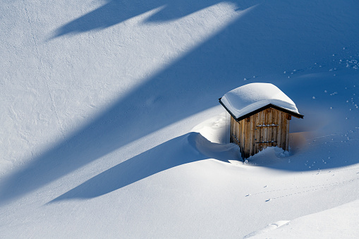 Snow covered small hut in the mountains