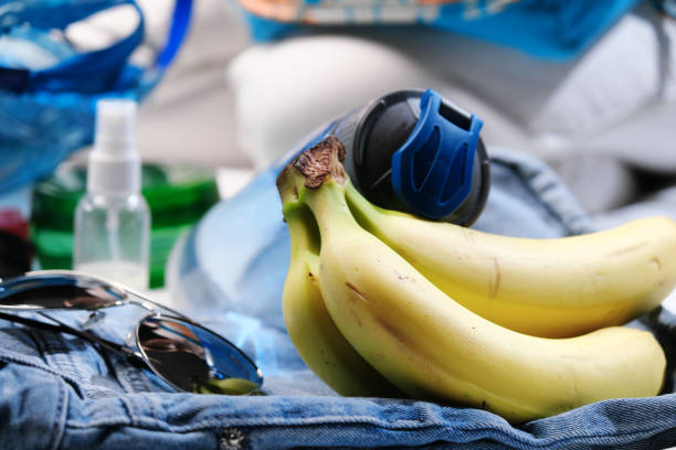 Woman is sitting on bed and packing beach bag