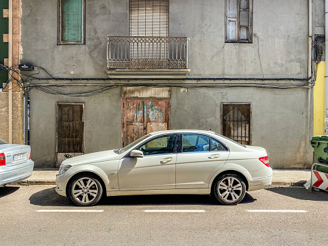 Valencia, Spain - June 27, 2021: White Mercedes-Benz car model Class C 220 parked in the street. The German manufacturer produces it since 1993 until the present day