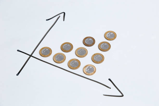 coins on white surface and arrows indicating time and earnings growth stock photo