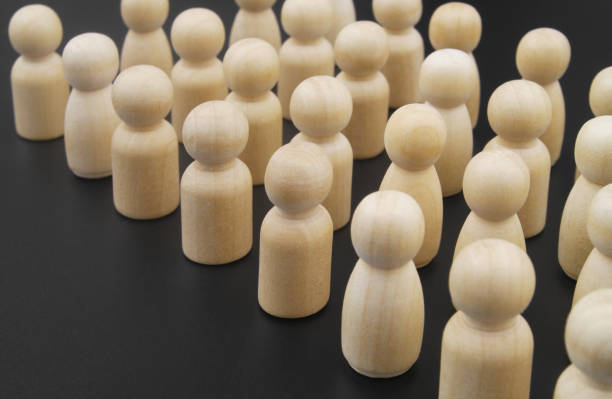 istock Many wooden figures standing close to each other on black background 1369724936