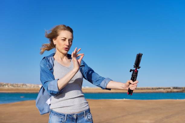 istock Mature woman recording video on smartphone, making a stream 1369725052