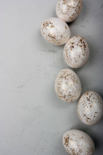 Decorated with golden glitter Easter eggs on plain background stock photo