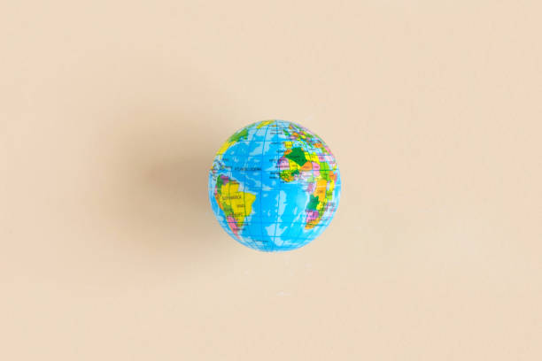 istock Earth globe on isolated beige pastel background. Abstract wallpaper. Civilization. Top view, flat lay, copy space. Planet Earth model. Close up of world globe. Atlantic Ocean 1369728078