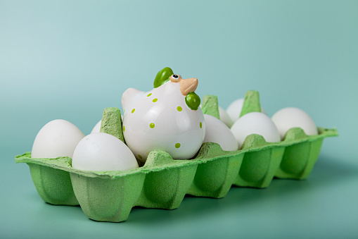 Happy Easter. Easter eggs. Chicken white eggs on green background. Easter chicken in one cell. Closeup.