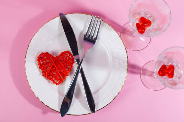 istock Valentine's day romantic dinner with red hearts on pink background. 1369729315