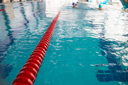 Carriles de piscina en la piscina de competición.carril de cuerda de plástico rojo en agua azul piscina cubierta fondo de competición deportiva. Enfoque selectivo. photo