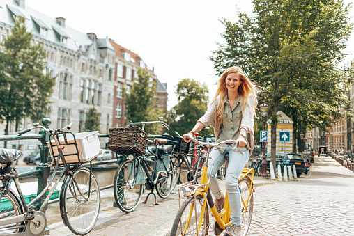 beautiful woman walking with the bike in amsterdam