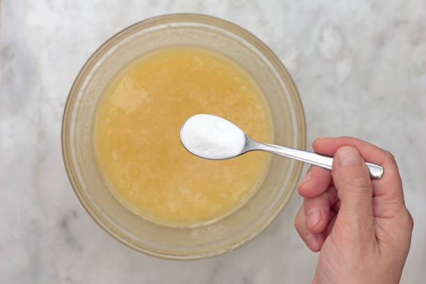 istock Hand putting baking soda into batter in glass bowl 1369730825