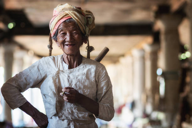 vieille dame birmane fumant un cigare et souriant au marché traditionnel du village d’indein, état shan, myanmar (birmanie) - burmese culture photos et images de collection