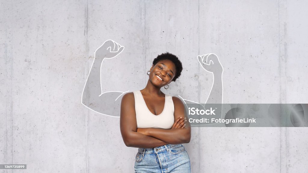 portrait of young happy afro woman looks in camera and shows muscles. success concept. Strength Stock Photo
