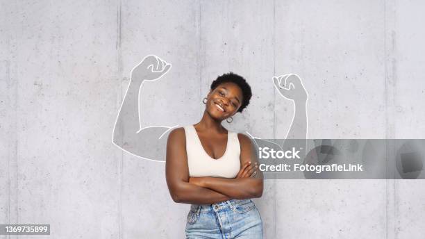 Portrait Of Young Happy Afro Woman Looks In Camera And Shows Muscles Success Concept Stock Photo - Download Image Now