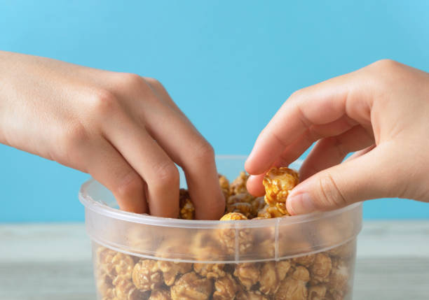 istock Kids eating caramel popcorn together. 1369738753