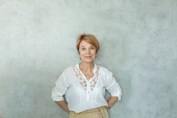 istock Smiling woman on gray background 1369739202