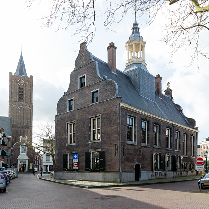 Schiedam, South Holland, Netherlands, february 5th 2022, daytime cityscape of Schiedam with the 17th century former townhall, and the medieval 'Sint-Janskerk' church in the background - the townhall is a national heritage site ('rijksmonument' no. 33128) as well is the church (no. 33240+33241) - Schiedam is known for its distilleries and for having the tallest windmills in the world, as a municipality it has a population of 80.000 (2021)
