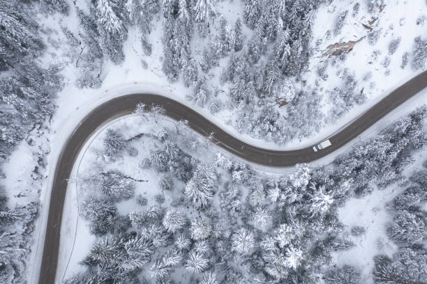 istock Truck Minibus Moving During Snowfall on a Winding Curving Mountain Road 1369741230