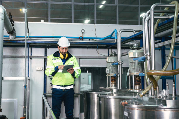 istock Caucasian technician engineer man in uniform with tablet checking and control boiler tanks and liquid pipeline in production line at factory 1369743960