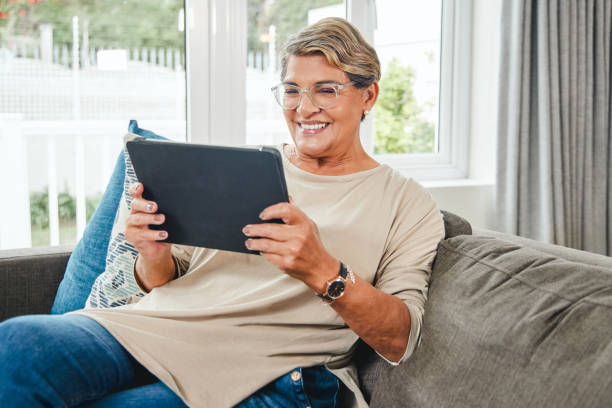 istock Shot of a mature woman using a digital tablet while relaxing at home 1369745063