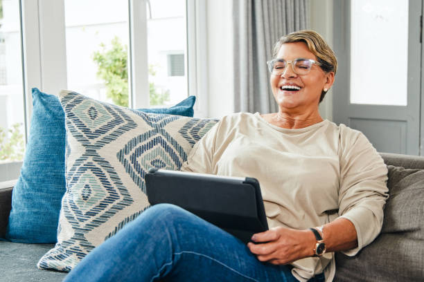 istock Shot of a mature woman using a digital tablet while relaxing at home 1369745071