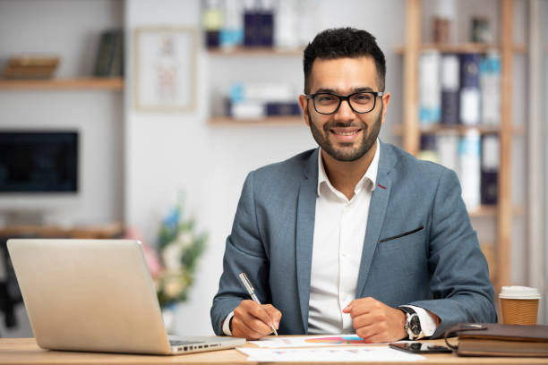 portrait of a handsome young businessman working in office - povo indiano imagens e fotografias de stock