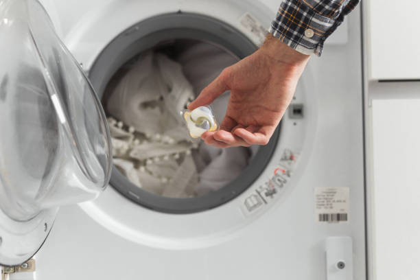 istock Gel caps in hand for washing machine, liquid coloured detergent and conditioner 1369748012