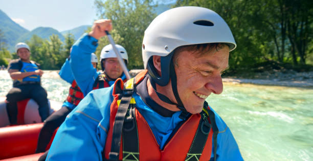 Group of rafting team paddling their raft in the river on a sunny day.