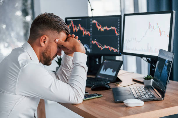istock Focusing on the work. Young businessman in formal clothes is in office with multiple screens 1369748119