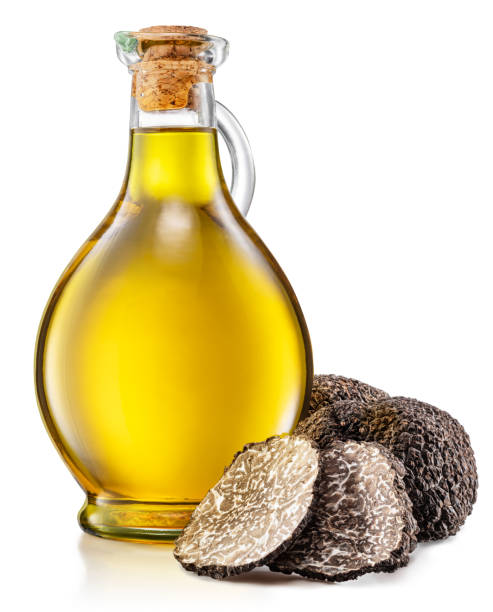 Truffle oil and black edible winter truffle on white background. stock photo
