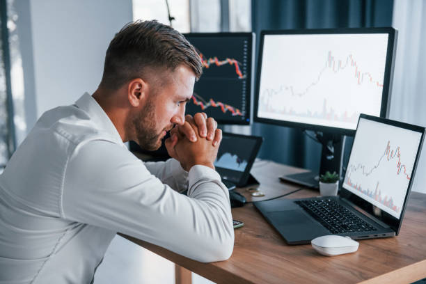 istock Focusing on the work. Young businessman in formal clothes is in office with multiple screens 1369748363