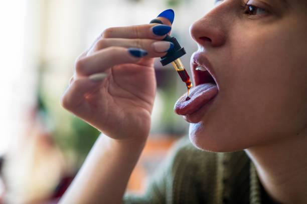 istock Self medication of CBD oil using a dropper. 1369750264