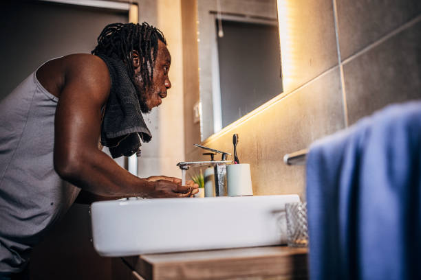 istock Man washing face in bathroom 1369750511