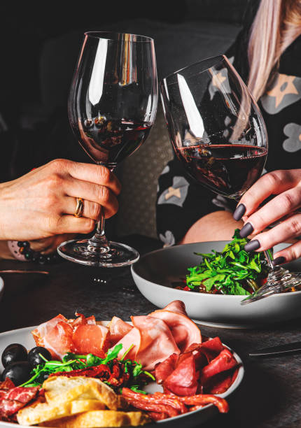 two glasses of red wine in woman hands clinking in cafe or restaurant - rose rosé women valentines day imagens e fotografias de stock