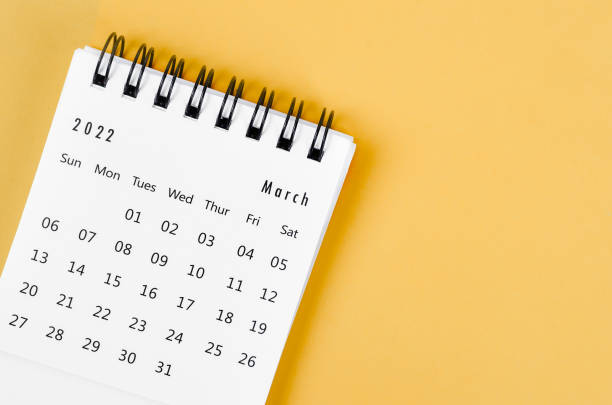 istock March 2022 desk calendar on light yellow background. 1369750896
