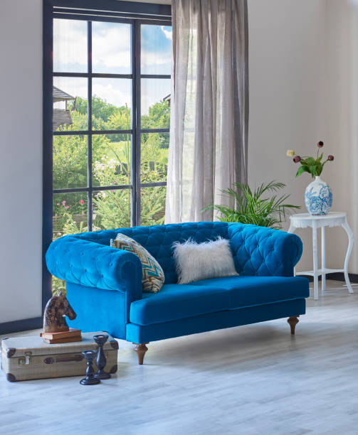 istock Carpet at home style with blue sofa parquet floor, home wall background lamp and table decoration. 1369753048