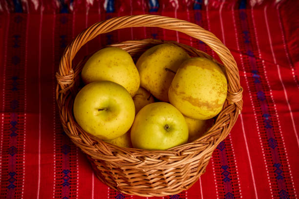 a basket of Gold apples on a table