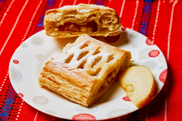 Homemade apple strudel with phyllo pastry, cinnamon, sultanas, almonds on white background. Apfelstrudel. Food recipe background, austrian germany food.