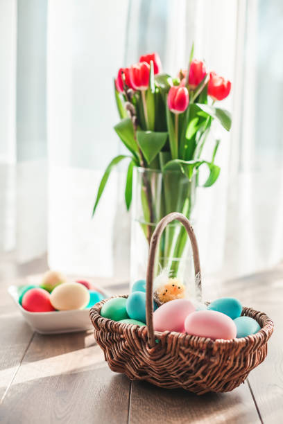 istock Easter eggs in a basket with tulips on a background 1369755724