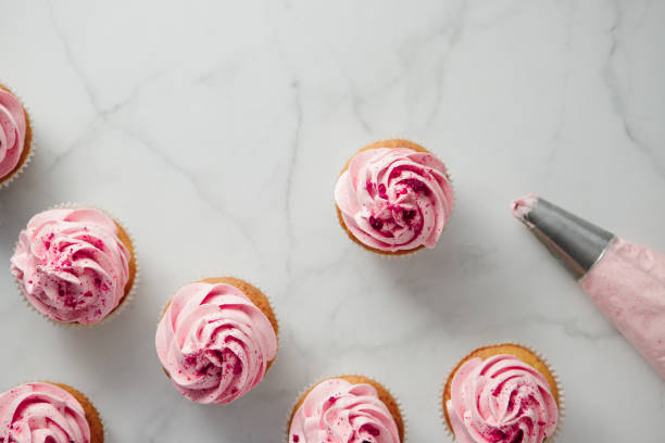 istock Freshly homemade pink cupcakes on the marble table top 1369757645