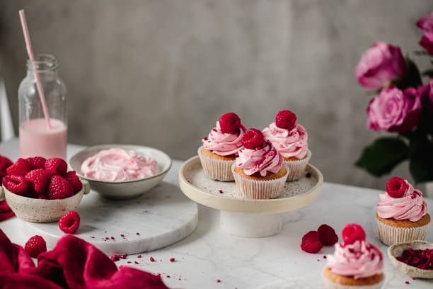 istock Freshly baked pink cupcakes on kitchen table 1369757703