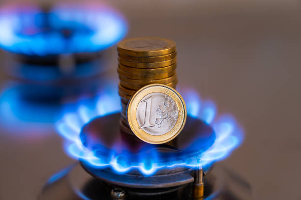 Gas cooking stove on, with coins. Gas cost. stock photo