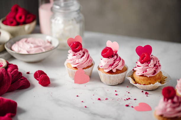 istock Delicious pink cupcakes on kitchen counter 1369757783