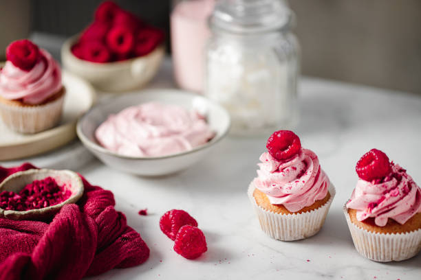 istock Homemade delicious pink cupcakes with ingredients on kitchen table 1369757784