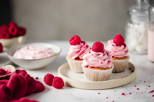 istock Freshly made cupcakes with pink cream and fresh raspberries 1369757786