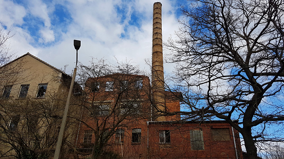 External view of the modern biomass power plant with smoking chimney on the beautiful blue sky background